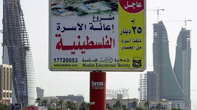 توضيحية: لوحة إعلانية تم تصويرها في 7 مايو، 2006، عند الواجهة البحرية للعاصمة البحرينية، المنامة، كُتب غليها ’مشروع إعانة الأسرة الفلسطينية. عاجل. ب25 دينار (9.50 دولار أمريكي) تنقذ أسره من الحصار’. (AP/Hasan Jamali) توضيحية: لوحة إعلانية تم تصويرها في 7 مايو، 2006، عند الواجهة البحرية للعاصمة البحرينية، المنامة، كُتب غليها ’مشروع إعانة الأسرة الفلسطينية. عاجل. ب25 دينار (9.50 دولار أمريكي) تنقذ أسره من الحصار’. (AP/Hasan Jamali)