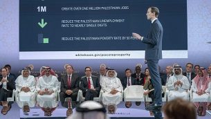 وزير الخزانة الأمريكي ستيفين منوشين، الخامس من اليسار، وولي العهد البحريني سلمان بن حمد آل خليفة، السادس من اليسار، يستمعان للمستشار الكبير للبيت الأبيض جاريد كوشنر، الواقف في الصورة، خلال الجلسة الافتتاحية لورشة "السلام من أجل الازدهار" في المنامة، البحرين، 25 يونيو، 2019.  (Bahrain News Agency via AP)