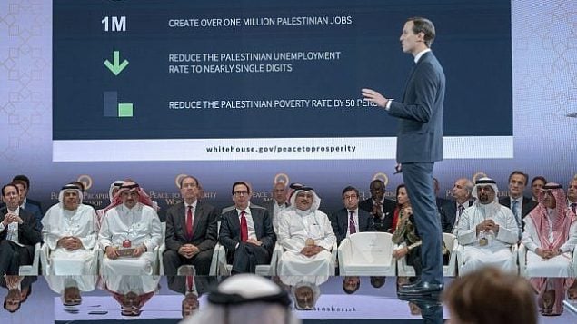 وزير الخزانة الأمريكي ستيفين منوشين، الخامس من اليسار، وولي العهد البحريني سلمان بن حمد آل خليفة، السادس من اليسار، يستمعان للمستشار الكبير للبيت الأبيض جاريد كوشنر، الواقف في الصورة، خلال الجلسة الافتتاحية لورشة "السلام من أجل الازدهار" في المنامة، البحرين، 25 يونيو، 2019.  (Bahrain News Agency via AP)