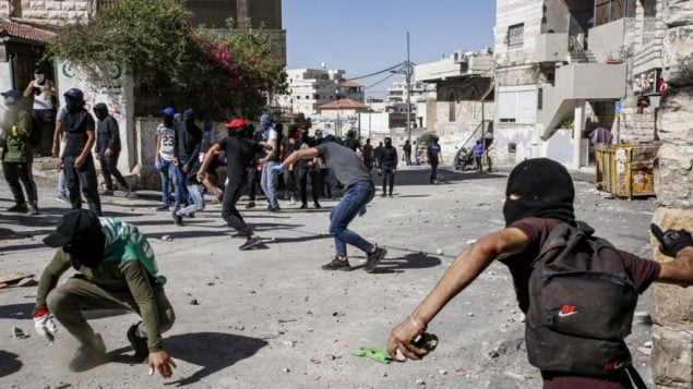 فلسطينيون يرشقون الحجارة خلال اشتباكات مع الشرطة في حي العيساوية في القدس الشرقية، 28 يونيو 2019 (Hazem Bader/AFP) فلسطينيون يرشقون الحجارة خلال اشتباكات مع الشرطة في حي العيساوية في القدس الشرقية، 28 يونيو 2019 (Hazem Bader/AFP)