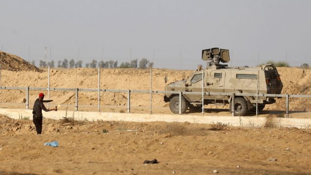 متظاهر فلسطيني يلقي زجاجة حارقة باتجاه مركبة عسكرية اسرائيلية خلال مظاهرات عند حدود غزة، 5 يوليو 2019 (SAID KHATIB / AFP)