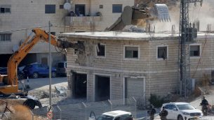 صورة التقطت من الضفة الغربية في 22 يوليو، تظهر قوات الامن الإسرائيلية تهدم احد المباني الفلسطينية التي كانت قيد البناء والتي صدرت اوامر بهدمها في منطقة وادي الحمص المتاخمة لقرية صور باهر الفلسطينية في القدس الشرقية (Hazem BADER / AFP)