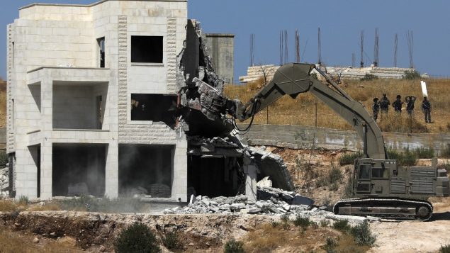 قوات الامن الإسرائيلية تهدم احد المباني الفلسطينية في قرية دار صلاح في الضفة الغربية، المتاخمة لمنطقة صور باهر، التي تقع بين الضفة الغربية والقدس، 22 يوليو 2019 (Ahmad GHARABLI/AFP)