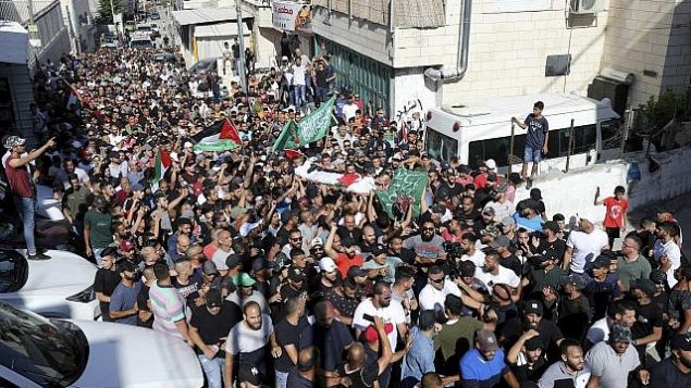 مشيعون يرفعون الأعلام الفلسطينية وأعلام حماس خلال جنازة الشاب الفلسطيني محمد عبيد (20 عاما)، الذي قُتل في 27 يناير في مواجهات مع الشرطة الإسرائيلية، القدس الشرقية، 1 يوليو، 2019.   (AP Photo/Mahmoud Ilean)
