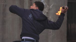 صورة توضيحية: فلسطيني يلقي زجاجة حارقة (Issam Rimawi/Flash90)