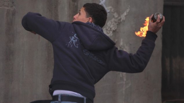 صورة توضيحية: فلسطيني يلقي زجاجة حارقة (Issam Rimawi/Flash90)