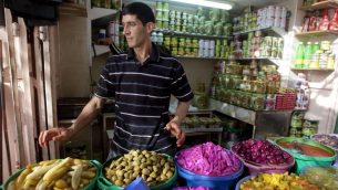 الطعام، بما في ذلك الخضراوات والزيتون المخللة، في أحد أسواق مدينة الخليل في الضفة الغربية، 28 يونيو، 2014.  (photo credit: AP/Majdi Mohammed)