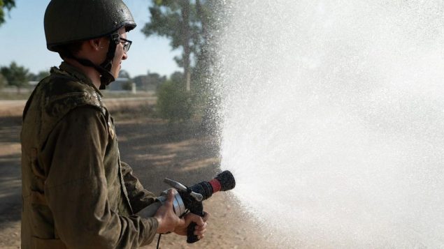جندي اسرائيلي يستخدم خرطوم اطفاء (Israel Defense Forces)