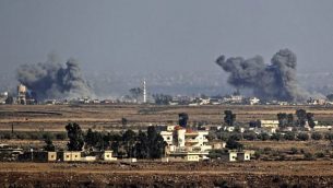 توضيحية: صورة تم التقاطها في 26 يوليو، 2018، بالقرب من كيبوتس عين زيفان على الجانب الإسرائيلي من هضبة الجولان، يظهر فيها الدخان وهو يتصاعد على الجانب الآخر من الحدود في سوريا في أعقاب غارة جوية خلال هجوم للنظام السوري على محافظة القنيطرة الجنوبية. (AFP Photo/Jack Guez)