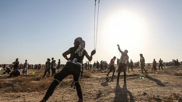 متظاهر فلسطيني يستخدم مقلاع لرشق الحجارة باتجاه القوات الإسرائيلية بالقرب من السياج الحدودي بين اسرائيل وقطاع غزة، 16 اغسطس 2019 (MAHMUD HAMS / AFP)