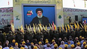 مناصرو منظمة حزب الله الشيعية اللبنانية يحتشدون لمتابعة نقل كلمة الأمين العام للمنظمة، حسن نصر الله، على شاشة كبيرة في بلدة العين في منطقة سهل البقاء اللبنانية، 25 أغسطس، 2019. (AFP)