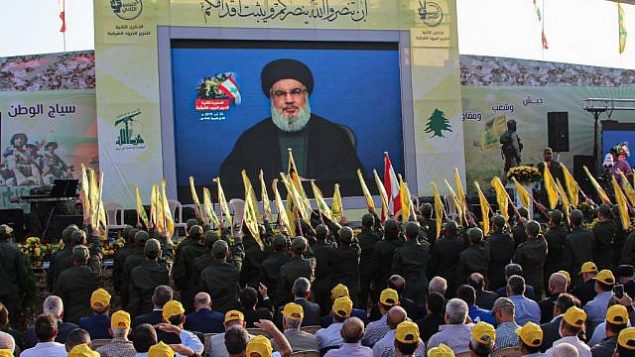 مناصرو منظمة حزب الله الشيعية اللبنانية يحتشدون لمتابعة نقل كلمة الأمين العام للمنظمة، حسن نصر الله، على شاشة كبيرة في بلدة العين في منطقة سهل البقاء اللبنانية، 25 أغسطس، 2019. (AFP)