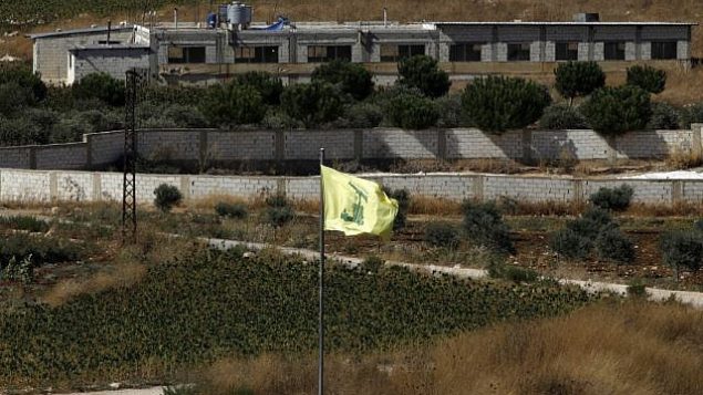 صورة تم التقاطها في 26 أغسطس، 2019، بالقرب من موشاف أفيفيم على الحدود الشمالية لإسرائيل يظهر فيها علم حزب الله في قرية عيترون اللبنانية.  (Jalaa Marey/AFP)
