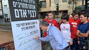 زعيم حزب ’العمل’ عمير بيرتس يوقع على التزام للحزب بالقيم الإنسانية، تل أبيب، 4 أغسطس، 2019.  (Courtesy)