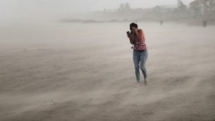 سيدة تحاول الاختباء من الرياح والامطار خلال اعصار دوريان في فلوريدا، 2 سبتمبر 2019 (Scott Olson/Getty Images/AFP)