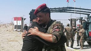جنديا حرس حدود عراقي وسوري يهنآن بعضهما البعض خلال مراسم افتتاح المعبر الحدودي بين بلدة القائم العراقية ومنطقة البوكمال السورية في محافظة الأنبار، العراق، 30 سبتمبر، 2019. (AP Photo/Hadi Mizban)