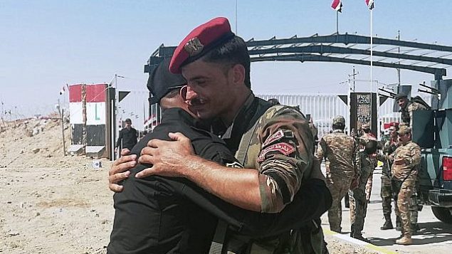 جنديا حرس حدود عراقي وسوري يهنآن بعضهما البعض خلال مراسم افتتاح المعبر الحدودي بين بلدة القائم العراقية ومنطقة البوكمال السورية في محافظة الأنبار، العراق، 30 سبتمبر، 2019. (AP Photo/Hadi Mizban)