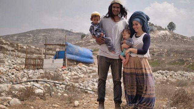 نيريا زاروغ (وسط الصورة) وزوجته وطفليه أمام منزلهم في بؤرة كيبا سروغا الاستيطانية، وهي حي في مستوطنة يتسهار بشمال الضفة الغربية. (Avraham Shapira)