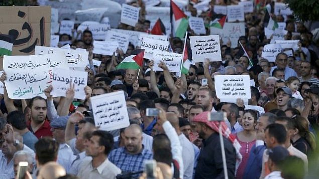 فلسطينيون يشاركون في تظاهرة للمطالبة برفع العقوبات عن قطاع غزة، في مدينة رام الله بالضفة الغربية، 23 يونيو، 2018.  (AFP/ ABBAS MOMANI)