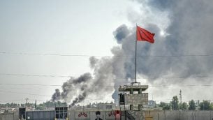 صورة تم التقاطها في بلدة أقجة قلعة على الحدود التركية مع سوريا في 10 أكتوبر، 2019 يظهر فيها الدخان وهو يتصاعد في بلدة تل أبيض السورية بعد سقوط قذيفة في حديقة مبنى حكومي تركي في أقجة قلعة. (BULENT KILIC / AFP)