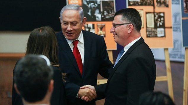 رئيس الوزراء بنيامين نتنياهو يصافح مرشح حزب ’الليكود’، غدعون ساعر، عند  وصوله إلى جلسة الحزب في ’مركز  مناحم بيغين للتراث’ في القدس، 11 مارس، 2019.  (Yonatan Sindel/Flash90)