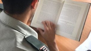 صورة توضيحية صدرت في 16 اكتوبر 2019، تظهر ضابط عسكري اسرائيلي يقرأ كتاب (Israel Defense Forces)