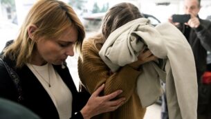شابة بريطانية (يمين) متهمة بالادعاء كذباً بأنها تعرضت للاغتصاب على أيدي سياح إسرائيليين، تغطي وجهها وهي تصل لمحكمة فاماغوستا، في بارالمني بشرق قبرص، 28 نوفمبر 2019 (Iakovos Hatzistavrou / AFP)