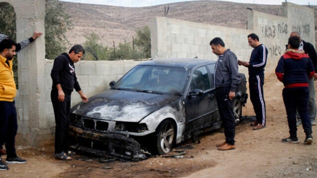 رجال فلسطينيون يتفقدون مركبة حُرقت في ما يُشتبه بأنها جريمة كراهية وقعت في قريدة بيت دجن بشمال الضفة الغربية، 22 نوفمبر، 2019.  (Nasser Ishtayeh/Flash90)