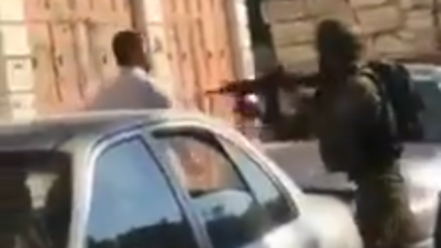 جندي إسرائيلي يوجه سلاحه تجاه رجل فلسطيني أمام طفله في الخليل، 5 نوفمبر، 2019. (Screenshot: Twitter) جندي إسرائيلي يوجه سلاحه تجاه رجل فلسطيني أمام طفله في الخليل، 5 نوفمبر، 2019. (Screenshot: Twitter)