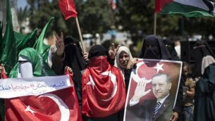 مناصرون فلسطينيون لحركة ’حماس’ يحملون صورا للرئيس التركي، رجب طيب إردوغان، ويهتفون شعارات ضد محاولة انقلاب عسكري في تركيا، خلال تظاهرة في مدينة غزة، 17 يوليو، 2016. (AFP/MAHMUD HAMS)