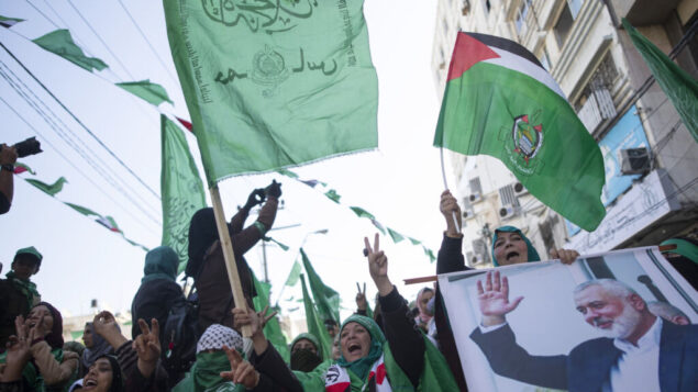 نساء فلسطينيات، تحمل إحدىهن صورة لزعيم حركة حماس إسماعيل هنية، يحضرن مظاهرة حاشدة للاحتفال بالذكرى الثانية والثلاثين لتأسيس حماس، في مدينة غزة، 14 ديسمبر 2019 (AP/Khalil Hamra)