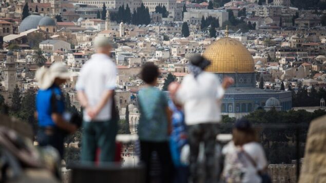 سياح ينظرون إلى منظر قبة الصخرة والحرم القدسي من الطور المطل على المدينة القديمة في القدس، 11 أكتوبر 2018. (Hadas Parush / Flash90)