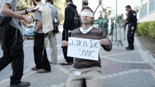 صورة توضيحية: ناشط يهودي يميني يحمل لافتة كتب عليها "لا تعذبني" خارج محاكمة منفذي هجوم دوما الدامي، في بتاح تكفا، 28 ديسمبر 2015. (Tomer Neuberg/Flash90)