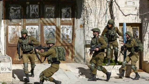 جنود إسرائيليون يوجهون بنادقهم خلال اشتباكات مع فلسطينيين بعد مداهمة في منطقة بيت لحم هذا الصباح بحثًا عن مشتبه به مطلوب في هجوم دهس في القدس في وقت سابق، أسفر عن إصابة 12 جنديًا، أحدهم بجروح خطيرة، 6 فبراير 2020 (Musa Al SHAER / AFP)