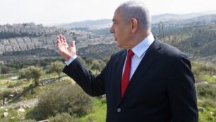 رئيس الوزراء بنيامين نتنياهو يقف في موقع يطل على حي هار حوما بالقدس الشرقية، 20 فبراير 2020. (Debbie Hill/Pool/AFP)