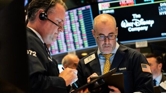 تجار يعملون على أرضية بورصة نيويورك (NYSE) في 12 مارس 2020 في مدينة نيويورك (Jeenah Moon / Getty Images / AFP)