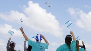 الطاقم الطبي في المركز الطبي شيبا في تل هشومير يلوح بالأعلام الإسرائيلية خلال عرض جوي لطائرات بهلوانية تابعة لسلاح الجو الإسرائيلي فوق المستشفى خلال احتفال إسرائيل بيوم الإستقلال في تحية للطواقم الطبية التي تحارب تفشي جائحة فيروس كورونا، 29 أبريل، 2020.(JACK GUEZ/AFP) الطاقم الطبي في المركز الطبي شيبا في تل هشومير يلوح بالأعلام الإسرائيلية خلال عرض جوي لطائرات بهلوانية تابعة لسلاح الجو الإسرائيلي فوق المستشفى خلال احتفال إسرائيل بيوم الإستقلال في تحية للطواقم الطبية التي تحارب تفشي جائحة فيروس كورونا، 29 أبريل، 2020.(JACK GUEZ/AFP)