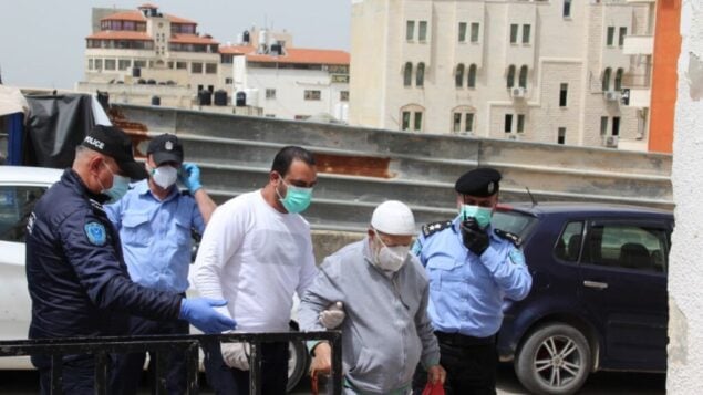 قوات أمن السلطة الفلسطينية ورجل مسن يقفون بالقرب من مدخل مستشفى ثابت ثابت الحكومي في طولكرم، 5 أبريل 2019. (Wafa)