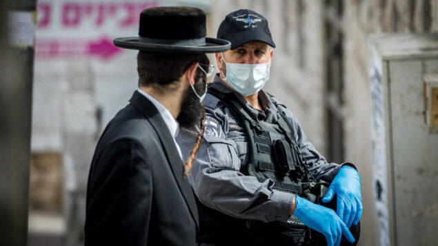 ضباط الشرطة يقومون بإغلاق كنس يهودية وتوزيع غرامات لليهود المتشددين في حي بخاريم في القدس، 6 أبريل 2020. (Yonatan Sindel / Flash90) ضباط الشرطة يقومون بإغلاق كنس يهودية وتوزيع غرامات لليهود المتشددين في حي بخاريم في القدس، 6 أبريل 2020. (Yonatan Sindel / Flash90)