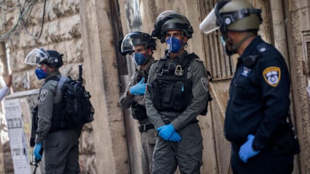 ضباط الشرطة خلال مداهمة في حي مئة شعاريم اليهودي المتشدد في القدس، 22 أبريل 2020. (Yonatan Sindel / Flash90)
