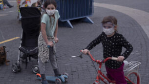 أطفال يضعون الكمامات في تل أبيب، 24 مارس، 2020.  (AP Photo/Oded Balilty)