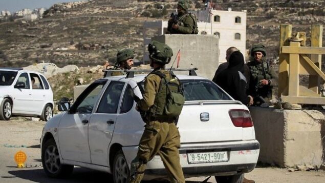 توضيحية: جنود إسرائيليون يقومون بتفتيش مركبات فلسطينية عند حاجز في قرية يطا بالضفة الغربية، 10 فبراير، 2017.(Wisam Hashlamoun/Flash90/File)