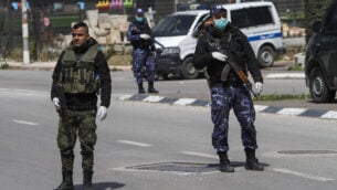 قوى الأمن الفلسطينية تقف عند مدخل مدينة نابلس في الضفة الغربية في 23 مارس، 2020، في إطار التدابير لإحتواء فيروس كورونا. (Nasser Ishtayeh/Flash90)