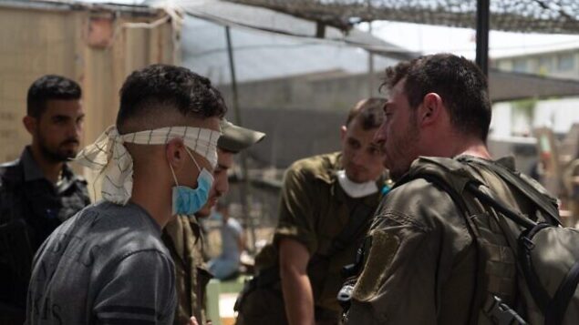 القوات الإسرائيلي تحقق مع شاب فلسطيني في إطار عمليات البحث عن الشخص المسؤول عن إلقاء طوبة على الجندي عميت بن يغال، والتي أسفرت عن مقتله، في قرية يعبد بالضفة الغربية، 13 مايو، 2020.(Israel Defense Forces)