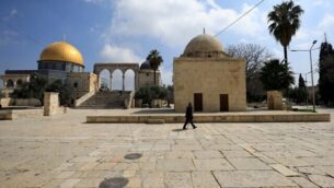 رجل يمر من امام قبة الصخرة في الحرم القدسي بالقدس القديمة، 16 مارس، 2020 (Emmanuel DUNAND/AFP)