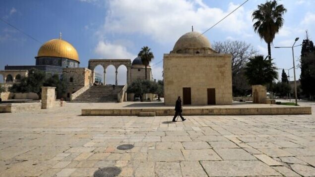 رجل يمر من امام قبة الصخرة في الحرم القدسي بالقدس القديمة، 16 مارس، 2020 (Emmanuel DUNAND/AFP)