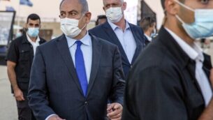 رئيس الوزراء بنيامين نتنياهو (وسط-يسار) وشريكه في الإئتلاف الحكومي، وزير الدفاع بيني غانتس (وسط-يمين)، يحضران حفل تخرج الطيارين الجدد في قاعدة ’حتساريم’ الجوية بالقرب من بئر السبع، في 25 يونيو 2020. (Ariel Schalit / POOL / AFP)