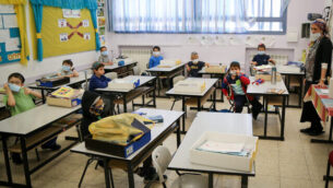 تلاميذ في مدرسة ’أوروت تسيون’ في مستوطنة إفرات بالضفة الغربية يضعون الأقنعة الواقية بعد عودتهم إلى التعليم لأول مرة منذ إغلاق المدارس بسبب جائحة فيروس كورونا. (Gershon Elinon/Flash90)