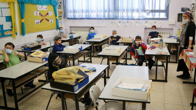 تلاميذ في مدرسة ’أوروت تسيون’ في مستوطنة إفرات بالضفة الغربية يضعون الأقنعة الواقية بعد عودتهم إلى التعليم لأول مرة منذ إغلاق المدارس بسبب جائحة فيروس كورونا. (Gershon Elinon/Flash90)