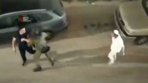 جندي إسرائيلي (وسط) يساعد رجلاً فلسطينيًا (يسار) على الفرار من مجموعة من الإسرائيليين الذين هاجموه في مدينة الخليل بالضفة الغربية، 13 يونيو 2020. (Screen capture: Twitter)